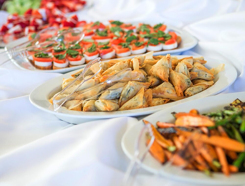 An appetizer buffet featuring roasted vegetables, spanakopita, bruschetta, and fresh fruit awaits guests in The Commons at the Minnesota Humanities Event Center.