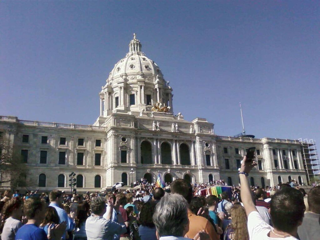 A crowd of people gather outside the Minnesota State Capitol building in St. Paul.