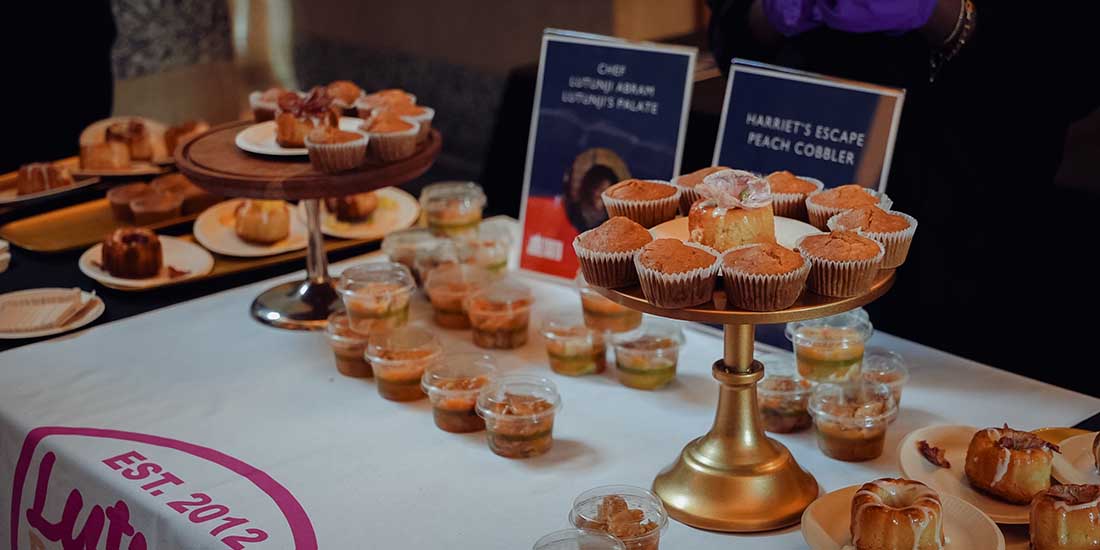 A table displays pastries and baked goods from a local Black chef at the 2025 Feeding Our Souls: The Essence of Juneteenth Joy.