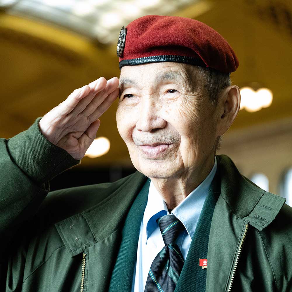 Colonel Khao Insixiengmay (Retired) salutes during salutes at an event recognizing the end of the Vietnam War, Secret War in Laos, and Southeast Asian conflict at Union Depot in St. Paul.